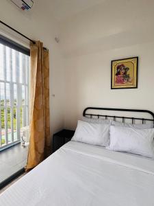 a bedroom with a white bed and a window at WV 29 Your Warm City Escape in Babuy