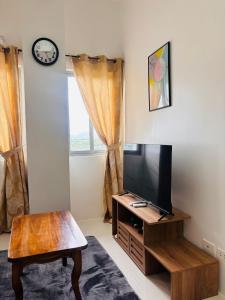 a living room with a tv and a table at WV 29 Your Warm City Escape in Babuy