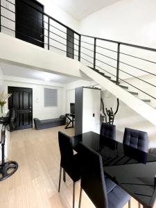 a living room with a staircase and a table and chairs at Prime City Location - 3 Bedroom Unit in Lapu Lapu City +19 photos