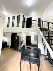 a living room with a staircase and a table at Prime City Location - 3 Bedroom Unit in Lapu Lapu City