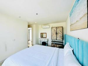 une chambre avec un lit avec une tête de lit bleue dans l'établissement Oceanami Villa Resort Deluxe King - Đầy đủ tiện nghi - Hồ bơi 2000 m2 - Long Hải Beach, à Long Hải
