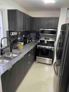 a kitchen with a stainless steel stove and refrigerator at Luxury Balcony Condo in Santo Domingo Norte in El Cachón