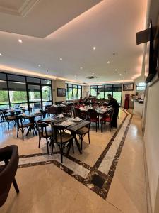 a dining room with tables and chairs and windows at Hotel Jardins Univer Pamplona com garagem 1808 in Sao Paulo