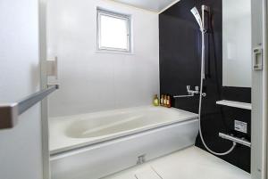 Shidoにあるアラハブルーリゾート901の窓のある浴室の白い浴槽 +35枚の写真