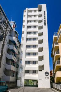 Shidoにあるアラハブルーリゾート901の2つの建物の隣にあるバルコニー付きの白い建物