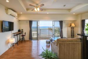 Shidoにあるアラハブルーリゾート901のソファと天井ファンのあるリビングルーム