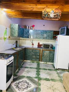 Una cocina con estufa y refrigerador blanco. en Casa Rojas, en Encarnación