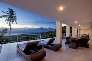 a balcony with chairs and a view of the ocean at Villa Skyline Lombok in Lajor