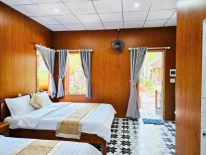 a bedroom with two beds and a window at Châu Homestay in Thôn Dương Xuân Hạ