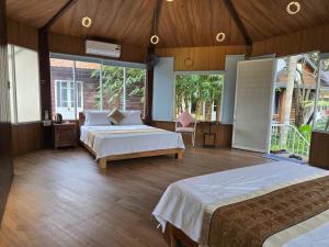 a large bedroom with two beds and a large window at Châu Homestay in Thôn Dương Xuân Hạ