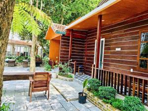 a wooden house with a wooden bench next to it at Châu Homestay in Thôn Dương Xuân Hạ