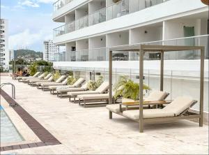 une rangée de chaises longues sur le côté d'un bâtiment dans l'établissement Exclusive apartment Cartagena, à Carthagène des Indes