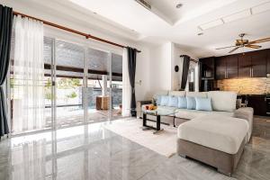 a living room with a couch and a table at Cozy Pool Villa near Kamala - 850 meter to the beach in Kamala Beach