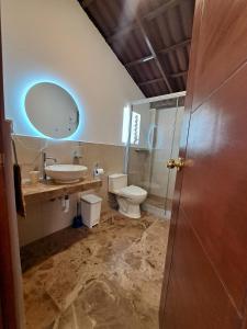 a bathroom with a sink and a toilet and a mirror at Centro recreativo y Casa de campo in Orcotuna