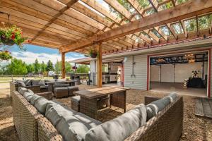 an outdoor patio with couches and a wooden pergola at Prairie Junction Glamping Tent in Stettler