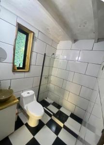 a bathroom with a white toilet and a window at Tiny Houses del bosque in Pichilemu +12 photos