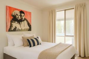 a bedroom with a bed with a painting on the wall at Bundalong River Retreat & Poolside Bliss in Bundalong