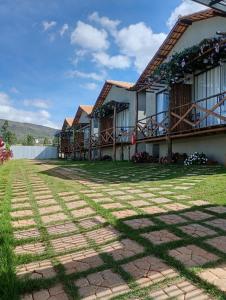 a house with a brick pathway in front of it at Chalés Vista dos Carvalhos in Capitólio