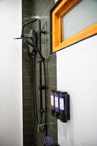 a bathroom with a black wall mounted shower at ตัง โฮเทล in Ban Rai Som