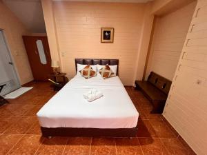 a bedroom with a large white bed with two pillows at Bunraksa Resort in Kamphaeng Phet