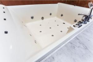 a white bath tub with a sink in a bathroom at B&B hotel in Changwon +39 photos