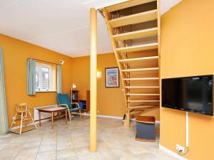 a living room with a spiral staircase and a living room at Thatched Cottage with Spa - By Traum Ferienwohnungen in Blåvand