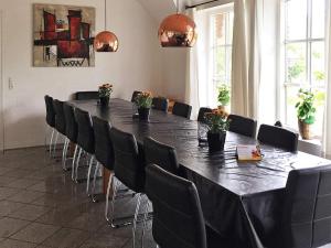 a conference room with a large black table and chairs at 18 person holiday home in Ulfborg-By Traum in Øby +39 photos