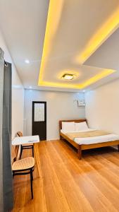 a bedroom with a bed and two chairs in it at Aladdin's Guest House in Coron
