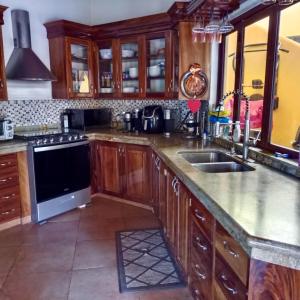a kitchen with wooden cabinets and a stove top oven at Paradise by the Playa in Los Ayala