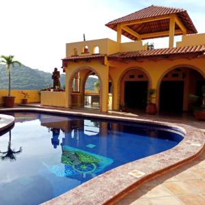 a swimming pool in front of a house at Paradise by the Playa in Los Ayala