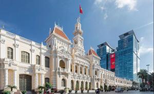 a large white building with a flag on top of it at HongHome Nguyễn Cửu Vân in Ho Chi Minh City