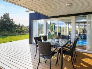 a wooden deck with a table and chairs on it at 5 star holiday home in Ringkøbing in Klegod +35 photos