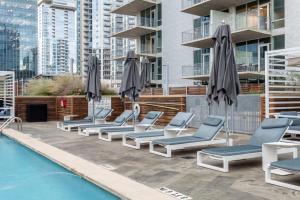 a row of lounge chairs and umbrellas next to a pool at Kasa 2Nd Street Austin in Austin