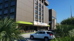 a white car parked in front of a building at Imperial Swan Hotel and Suites Lakeland in Lakeland