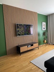 a living room with a television on a wall at Aardla Cozy Apartment in Tartu