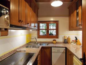 a kitchen with wooden cabinets and a sink at Casa Templers in Horta de San Joan