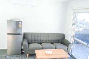 a living room with a couch and a refrigerator at Saints Apartment Junior Suite in Taupo