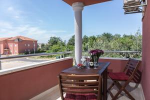 a table and chairs on a balcony with a view at Apartments Roža in Medulin