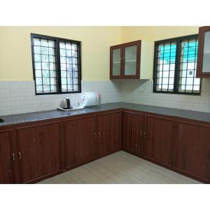a kitchen with wooden cabinets and a sink and windows at Greens Vagamon in Vagamon