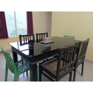 a dining room table with four chairs and a black table and chairsktop at Greens Vagamon in Vagamon