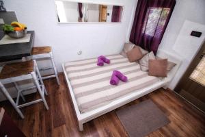 een bed met paarse slippers op de kamer bij Apartments Nevija in Rovinj