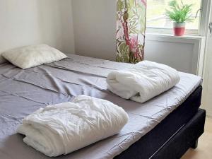 two pillows sitting on top of a bed with a window at 4 person holiday home in Götene in Götene