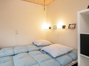 a bed in a room with blue and white pillows at 4 person holiday home in Ærøskøbing in Ærøskøbing