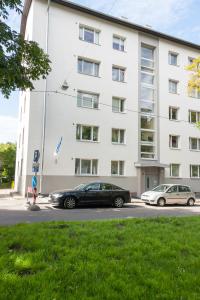 two cars parked in front of a building at Lastekodu Apartment in Tallinn