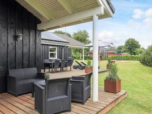 a patio with chairs and a table on a deck at 10 person holiday home in Hadsund in Hadsund