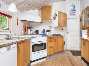 a kitchen with wooden cabinets and white appliances at 5 person holiday home in Hovborg in Hovborg
