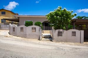 ウィレムスタッドにあるCasa24 Villa-Style Home, Big Kitchen & Parking Willemstadの家の前の白い柵