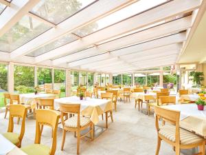a restaurant with tables and chairs and windows at Appartment Hotel Victoria in Bad Füssing