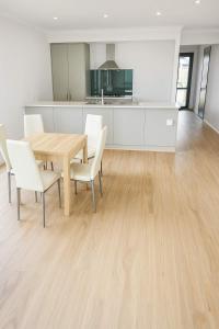 a kitchen and dining room with a wooden table and chairs at Byford Beauty Spacious Home with Large Bathrooms in each main room - Your Perfect Retreat in Byford