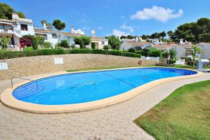 a large blue swimming pool in a yard at Vista Mar - modern, well-equipped bungalow in Moraira in Teulada